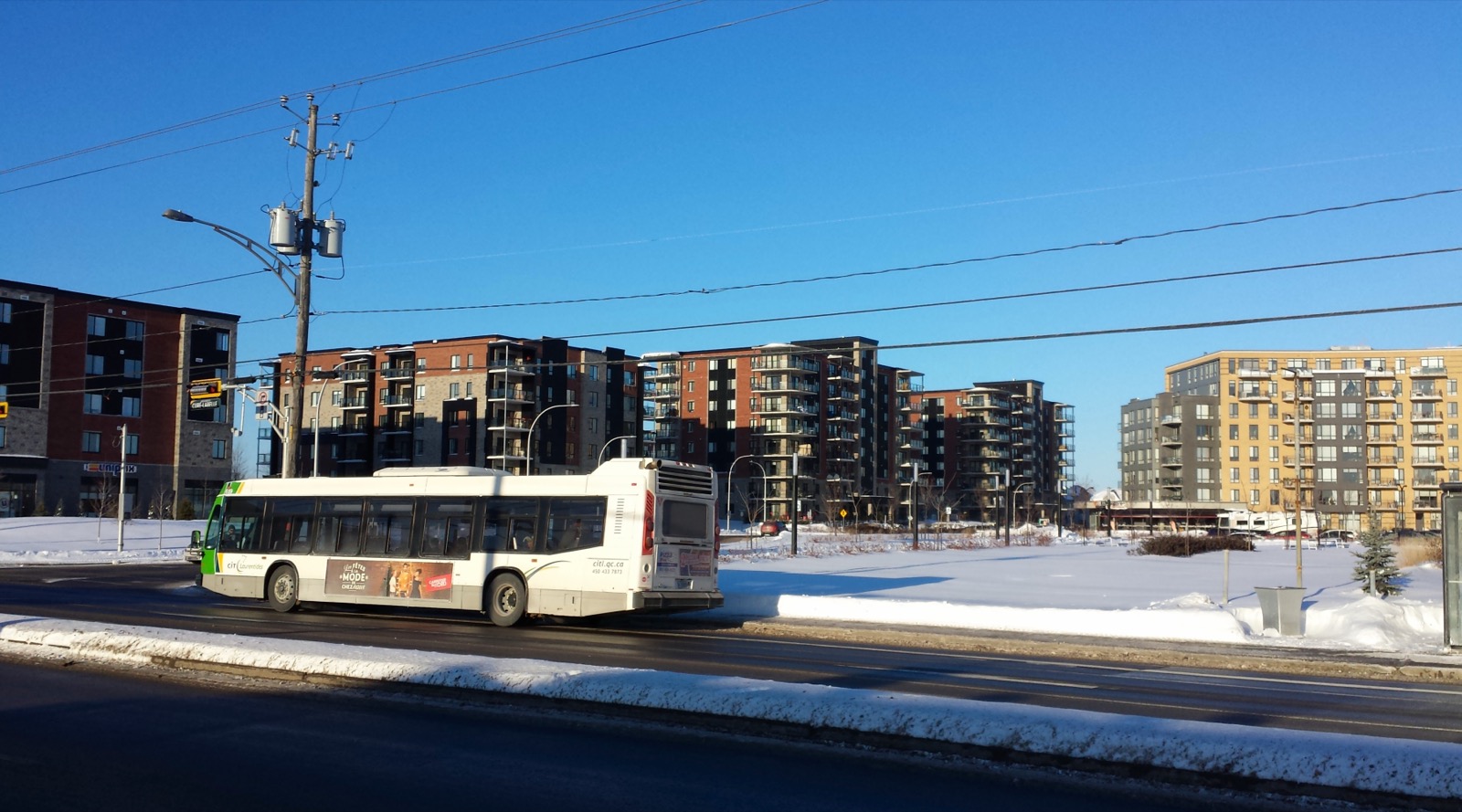 Immeubles résidentiels récents et autobus exo le long d'un boulevard de Blainville