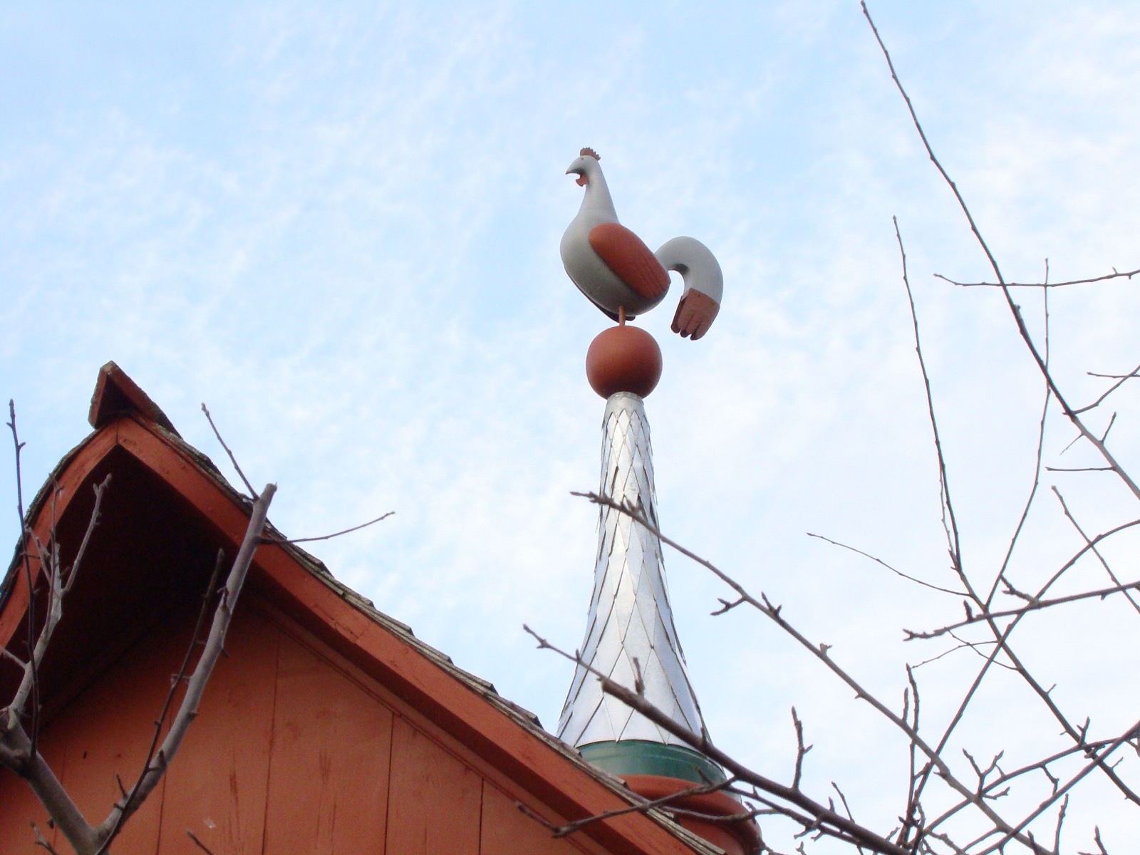 Girouette en forme de coq sur la toiture d'un bâtiment de ferme rouge, à Calixa-Lavallée
