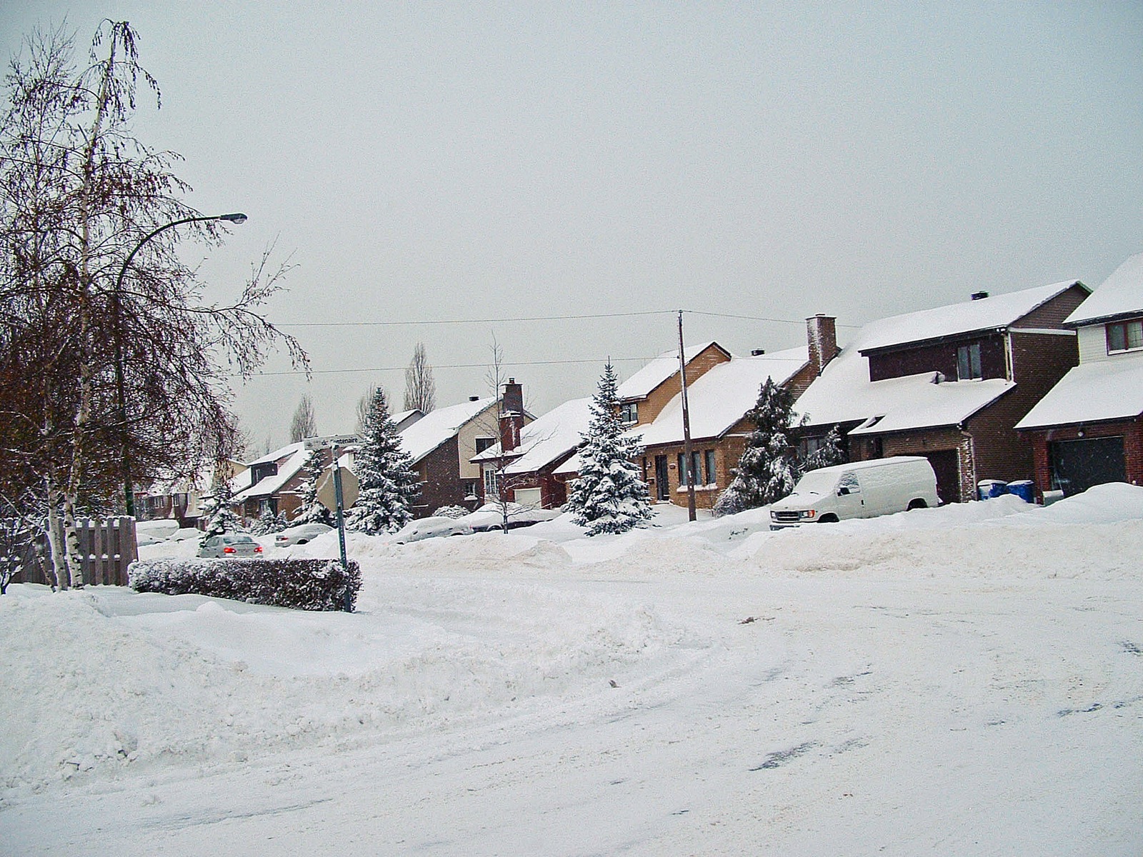Rue résidentielle de Greenfield Park sous la neige, bordée de maisons unifamiliales
