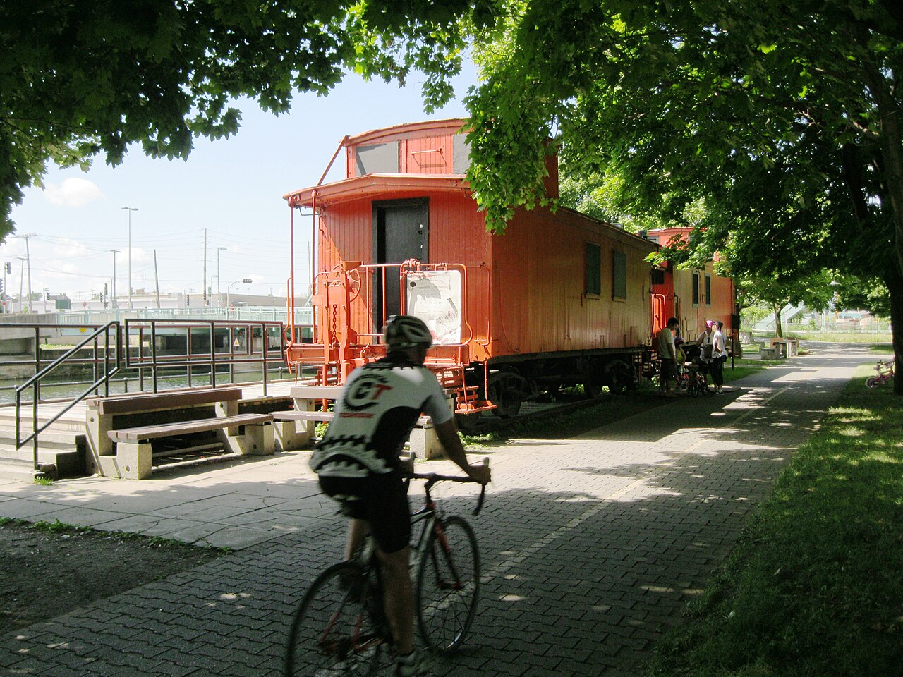 Cycliste sur la piste cyclable du canal de Lachine, près du wagon rouge de l'aire de repos