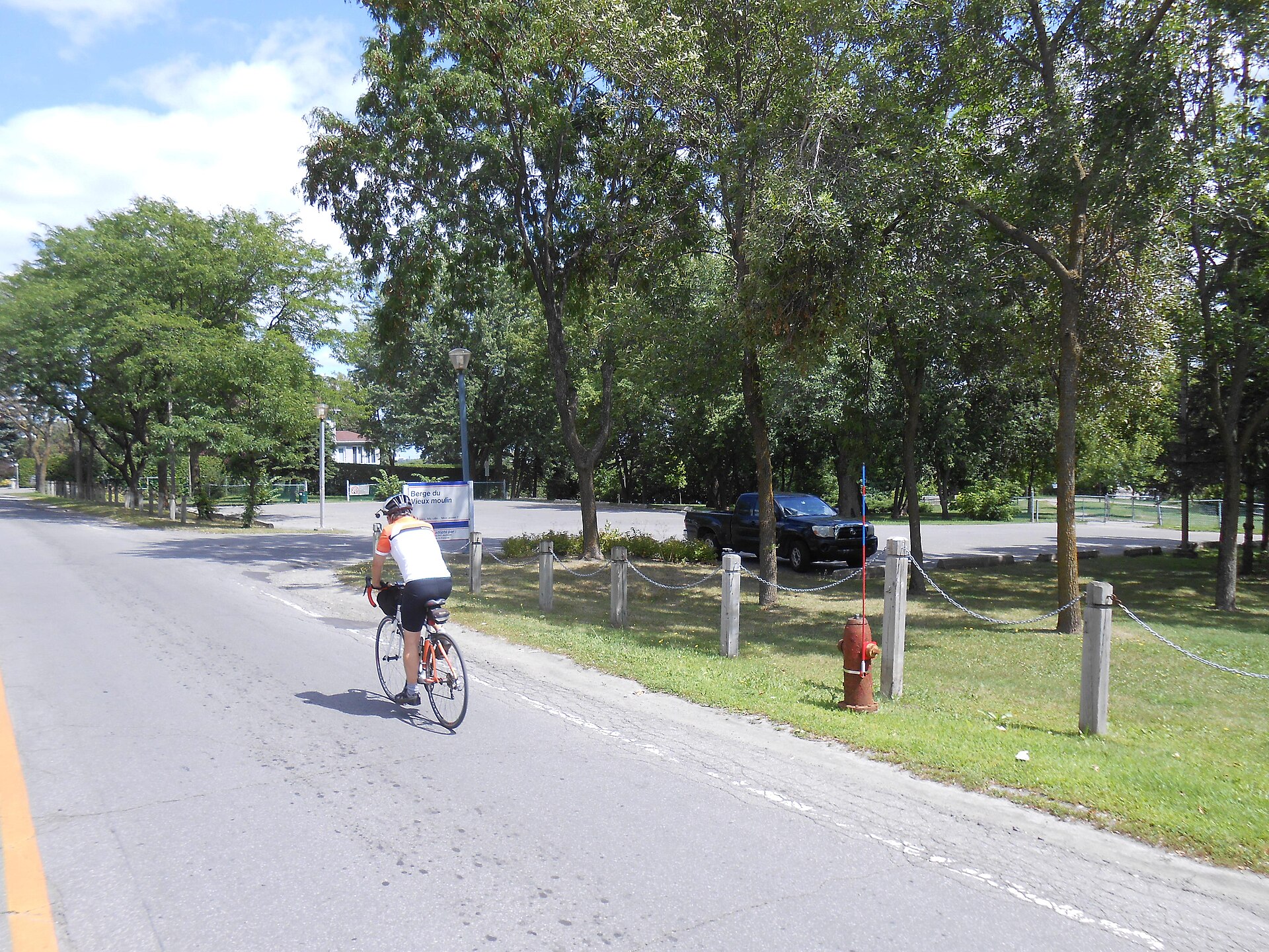 Un cycliste passe devant l'entrée de la berge du Vieux-Moulin, sur le boulevard Lévesque Est, à Laval