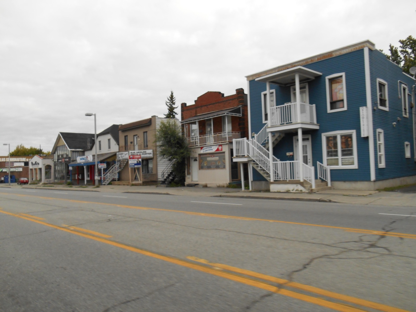 Duplex à escaliers extérieurs et petits commerces du boulevard des Laurentides, à Pont-Viau