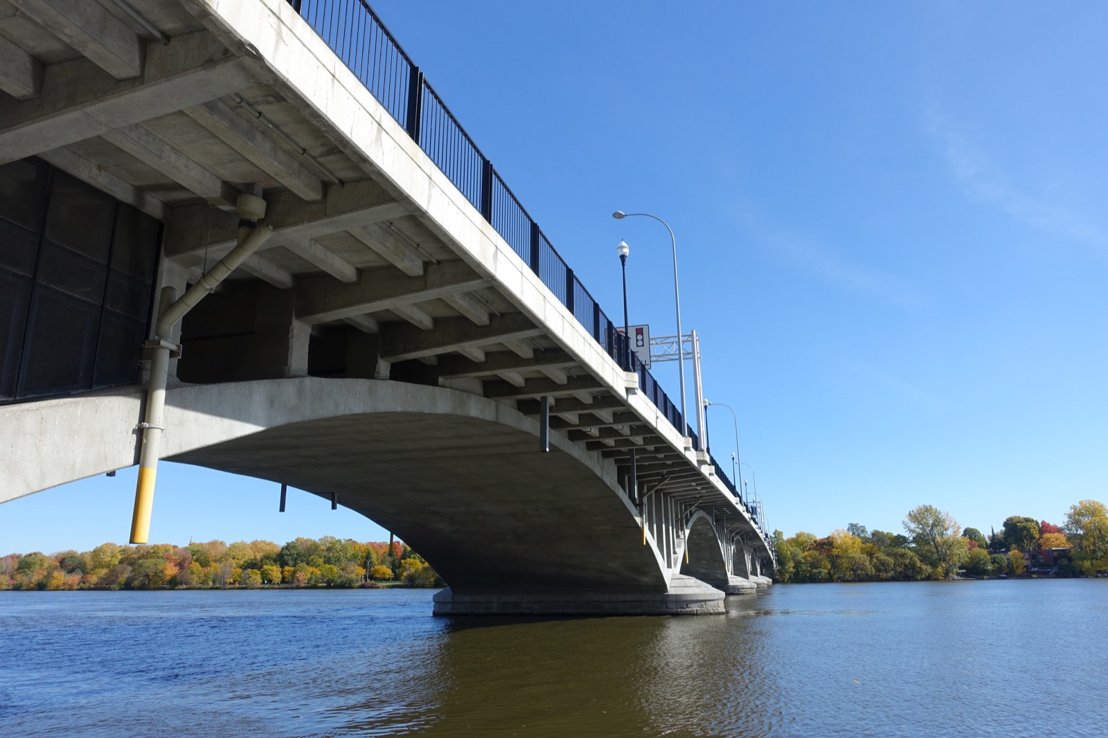 Les arches de béton du pont Viau vues d'en dessous, depuis la berge à Pont-Viau