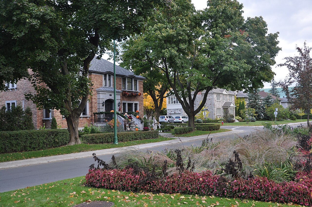Rue courbe et verdoyante de Ville Mont-Royal, avec terre-plein paysager typique du plan d'origine