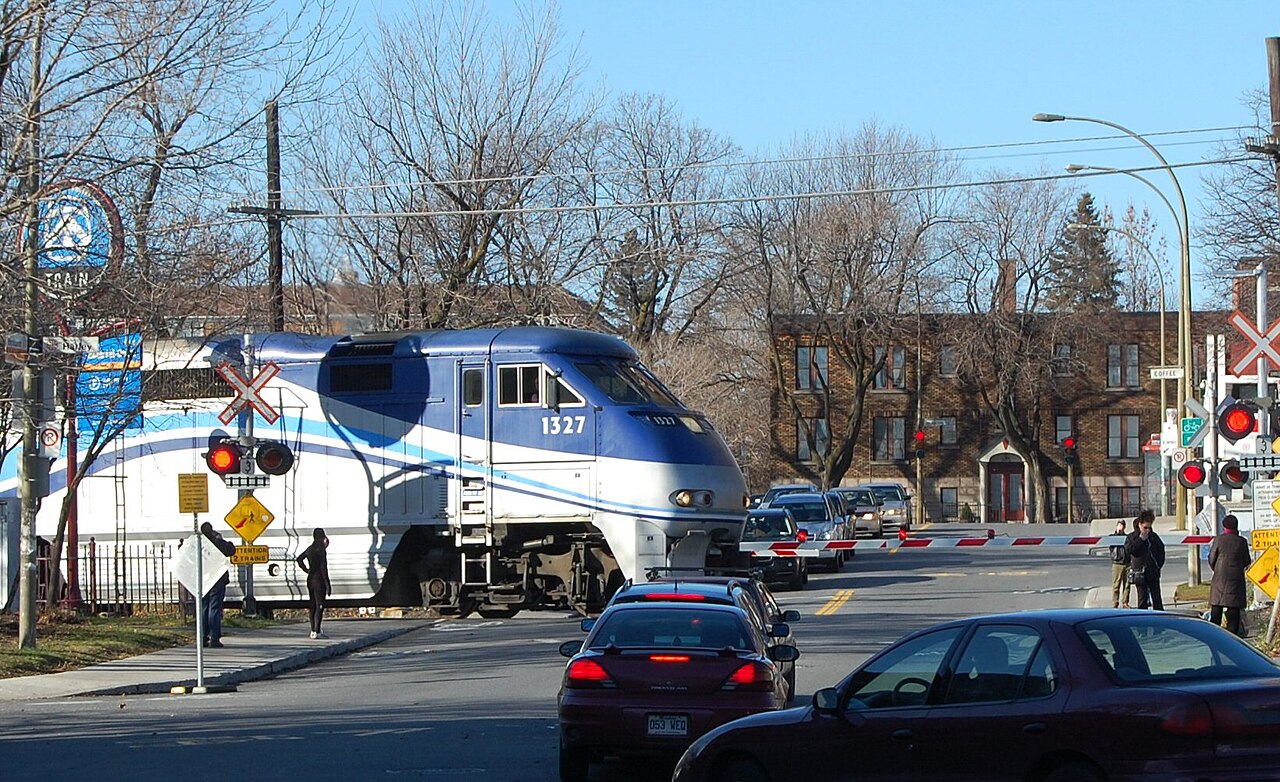 Un train de banlieue à la traverse à niveau, au cœur de Montréal-Ouest