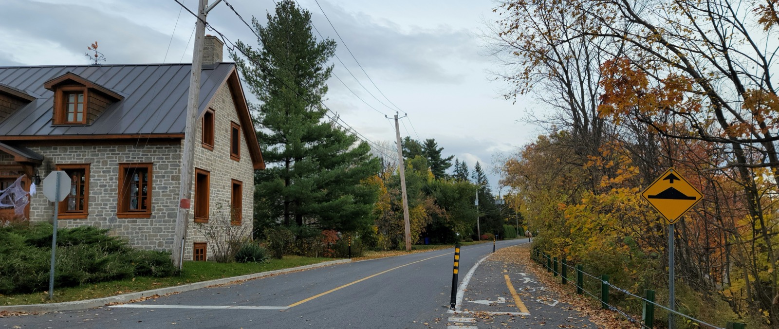 Une maison patrimoniale en pierre sur la 1re Rue de Richelieu, avec la bande cyclable qui longe la rivière