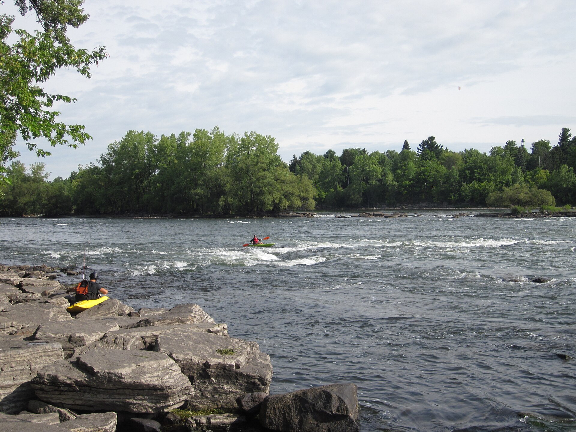 Les rapides de la rivière Richelieu au refuge faunique Pierre-Étienne-Fortin, avec un kayakiste et un pêcheur