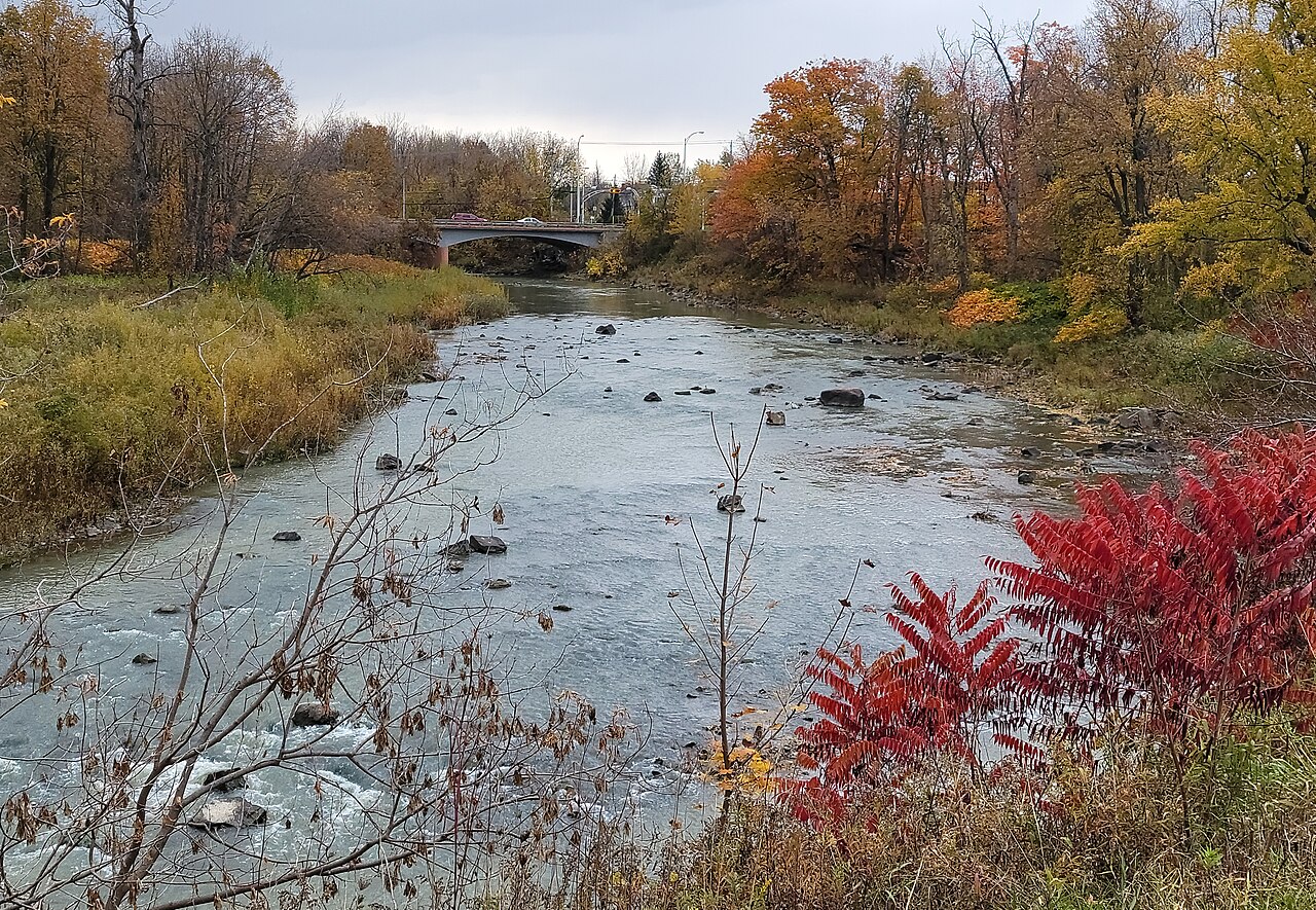 La rivière des Hurons aux couleurs d'automne, avec le pont de la route 133 en arrière-plan