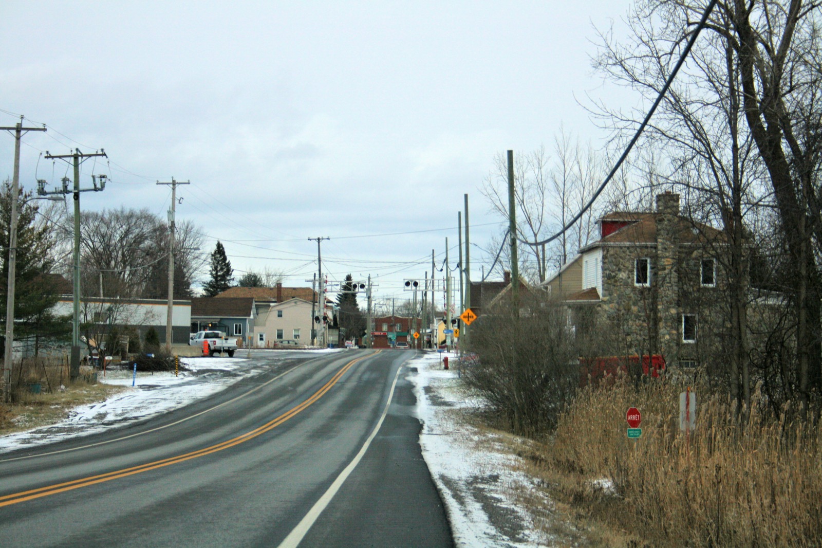 L'entrée du village de Saint-Philippe en hiver, avec son passage à niveau et ses maisons