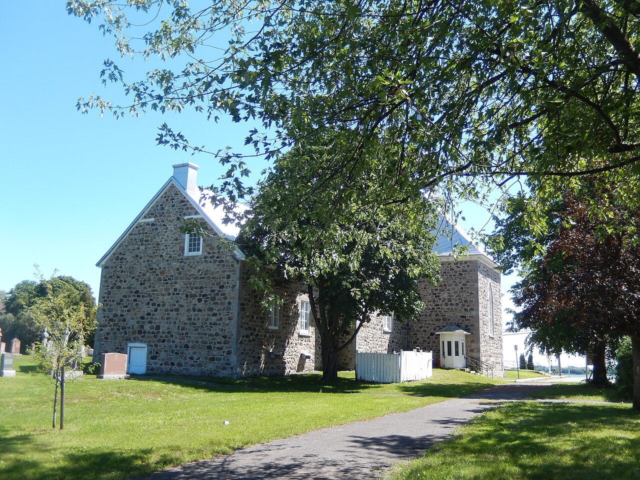 Le côté de l'église de Saint-Sulpice et son cimetière, avec le fleuve au fond