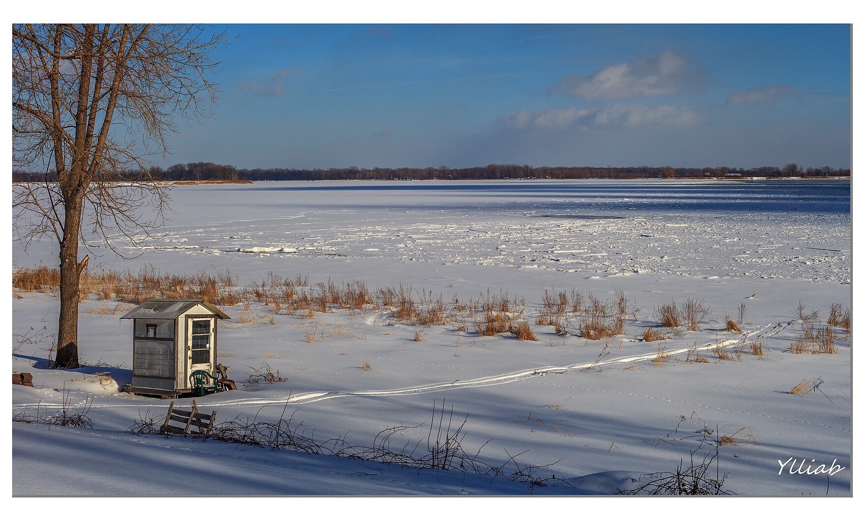 Le fleuve Saint-Laurent gelé et une cabane de pêche sur la rive, à Saint-Sulpice